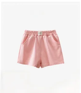 Detail view of pink cotton kids sports shorts featuring elastic waist and label