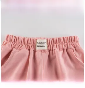 Close-up of pink children's shorts featuring elastic waistband and rectangular fabric label