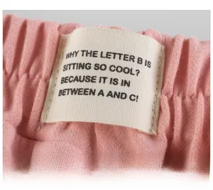 Close-up of pink knit kids shorts featuring elastic waistband and rectangle logo patch