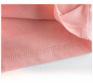 Detailed close-up of pink knit fabric showing rolled hem stitching and terry texture