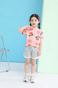Detail of girls' summer outfit with sunflower tee and grey shorts featuring white contrast trim