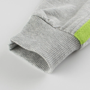 Girls heather grey joggers featuring elastic ribbed cuffs and neon green side stripes