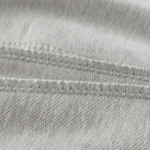 Detailed macro view of heather grey cotton knit fabric with durable double-needle stitching