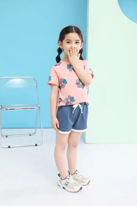 Detail view of toddler girl summer outfit with pink floral t-shirt and navy sports shorts