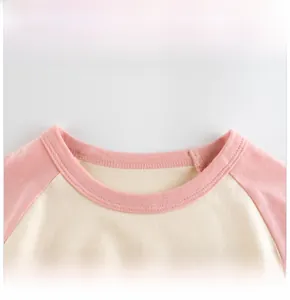 Vue détaillée des coutures plates et du col en coton de ce t-shirt raglan rose pour enfant