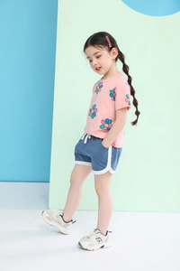 Detail of pink floral t-shirt and blue athletic shorts for girls summer wear