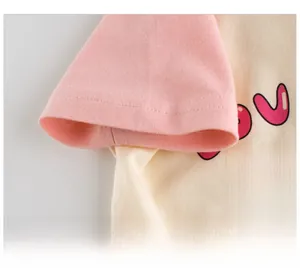 Détail des poignets roses et du tissu en coton doux d'un t-shirt pour fille avec cœur