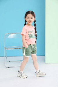Detailed shot of pink bear t-shirt and green drawstring shorts for young girls