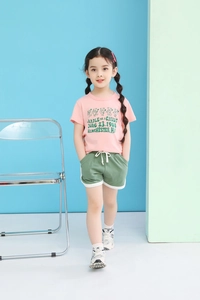 Detail of pink cotton T-shirt with cartoon bear and green drawstring shorts for girls