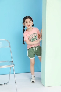 Detail of pink cartoon bear t-shirt and olive green athletic shorts with white drawstrings