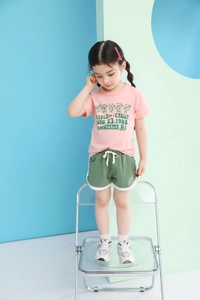 Detail of girls pink cotton T-shirt with bear print and green drawstring shorts set