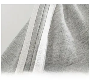 Dettaglio macro dei pantaloncini sportivi grigi con tre strisce laterali bianche