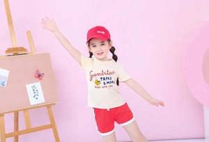 Kids summer outfit with beige t-shirt, red shorts and cap featuring lobster print detail