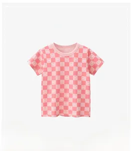 Detail of pink checkerboard kid's t-shirt showing smiley face print and ribbed crew neck