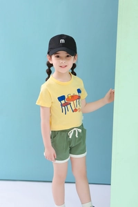 Detail of kids yellow t-shirt with table print and green drawstring shorts summer set