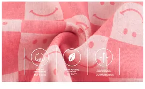 Detailed macro view of soft Class A cotton fabric with pink checkerboard and smiley print
