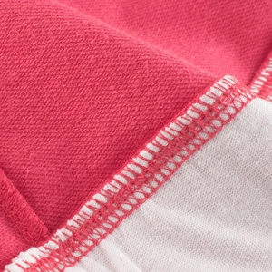 Close-up of pink girls' layered sweatshirt showing precise overlock stitching and knit fabric