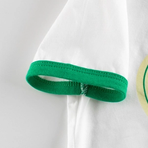 Close-up of white cotton kids T-shirt with green ringer sleeve and precise stitching detail