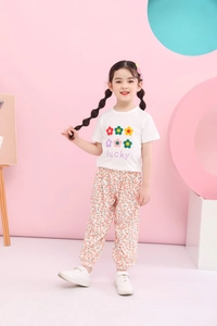 Mädchen Sommeroutfit Detail mit weißem Blumenprint T-Shirt und floraler Moskitohose
