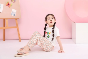 Detailansicht eines Mädchen Sommer-Sets mit weißem T-Shirt und Blumenhose in Orange