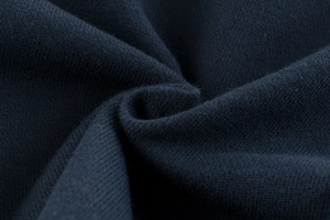 Close-up of navy blue knit fabric texture showing high-density weave and soft cotton feel