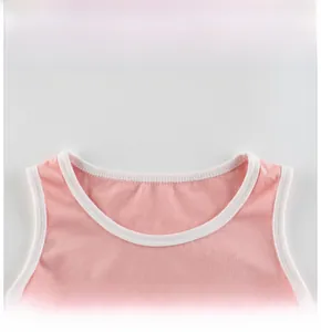 Detail showing the ribbed round neckline and soft cotton fabric of the pink girl's dress