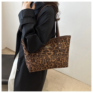 Détail du grand sac cabas en toile à motif léopard avec poignées en similicuir marron