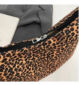 Macro detail of smooth silver zipper and stitching on leopard print canvas bag