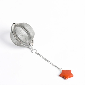 Stainless steel mesh tea infuser with chain and red crystal star charm on white background