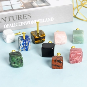Natural crystal stone cabinet knobs in square cube shapes with golden metal hardware