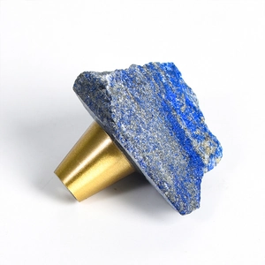 Natural lapis lazuli stone furniture handle with a matte brass conical base on white background