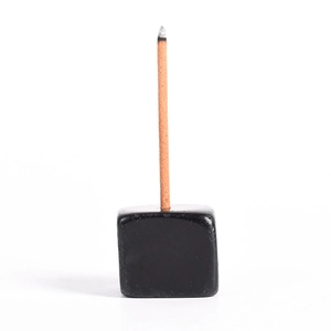 Minimalist black cube incense burner with stick showing polished stone base design