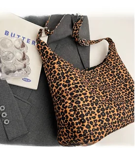 Detail of leopard print hobo bag with adjustable strap on a gray blazer setting