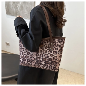 Détail du sac cabas en toile léopard avec poignées en cuir et coutures de précision