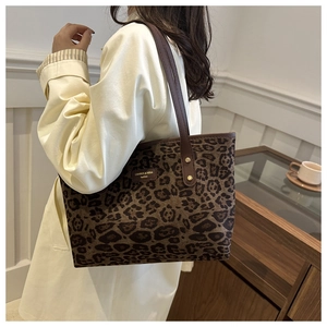 Détail d'un sac cabas en suédine léopard avec bandoulières marron et logo
