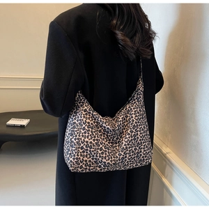 Chic leopard print canvas tote bag styled with a black coat on a model shoulder