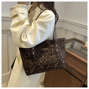 Détail du sac cabas léopard avec poignées en cuir marron et rivets dorés