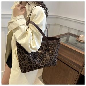 Détail du sac cabas léopard avec bandoulière en cuir marron et étiquette de marque