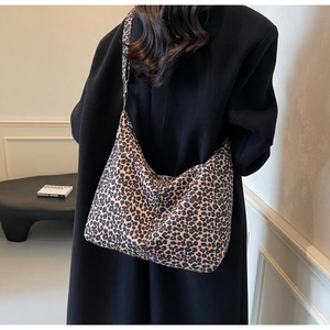 Rear view of a model carrying a large leopard print canvas tote bag over the shoulder