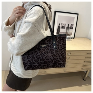 Détail d'un sac cabas tendance à imprimé léopard avec logo en métal sur fond de style