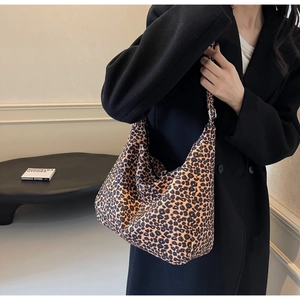 Close-up of leopard print canvas tote bag with adjustable metal buckle on shoulder strap