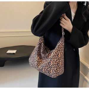 Detail view of the leopard print canvas bag showing the adjustable metal strap buckle