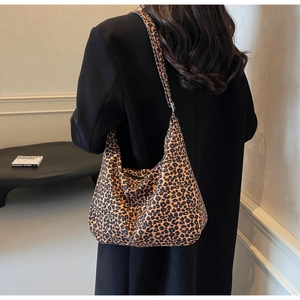 Leopard print hobo bag worn by a model in a modern interior, showing size and fit