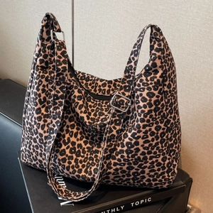 Detailed shot of large leopard print tote bag with adjustable strap and metal buckle