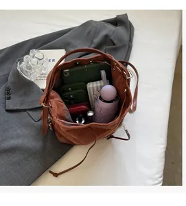 Interior view of brown bucket bag showing capacity for tablet, phone, and daily items