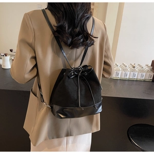 Chic black matte suede bucket backpack with drawstring and sleek leather base for women