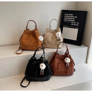 Minimalist matte bucket bags in four colors with plush eye pendants and drawstring closure