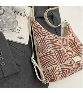 Detail of jacquard canvas saddle bag with brown pattern on a dark grey blazer