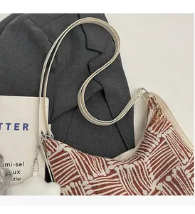 Close-up of woven geometric tote bag texture with plush ball charm and white strap