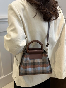 Sac à carreaux rétro avec poignées en résine marron porté par un mannequin
